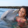 A young girl receives a kiss from the dolphin at the Dolphin Academy Curaçao.